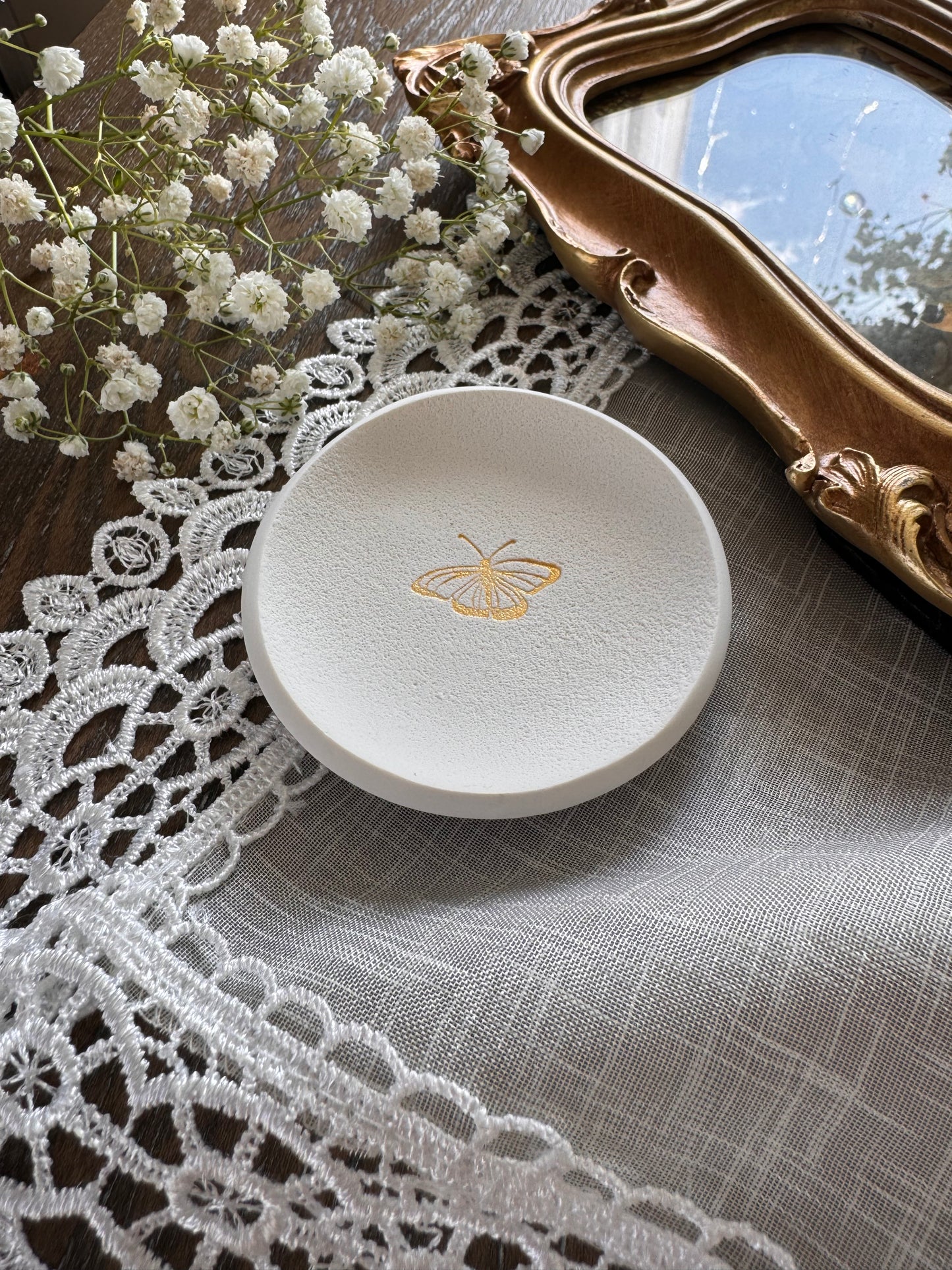 white clay ring dish with butterfly design in center, perfect for photography props