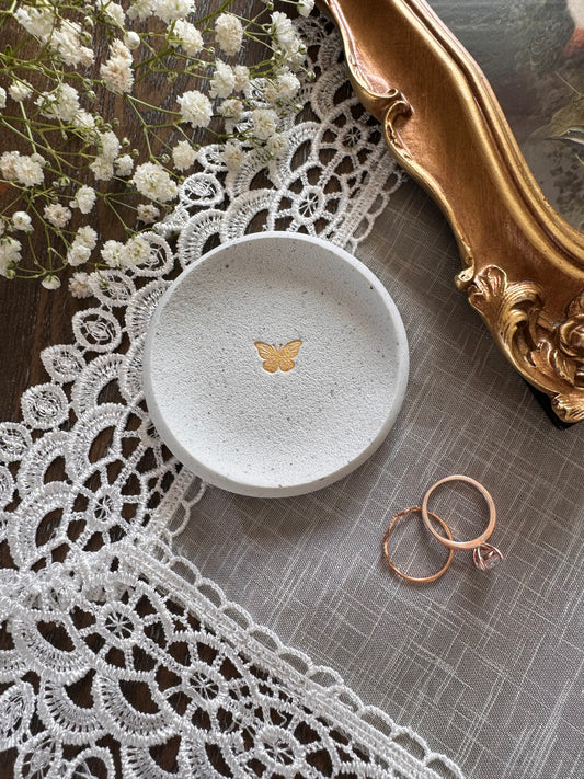 white clay speckled ring dish with gold simple butterfly in center, perfect for photography prop