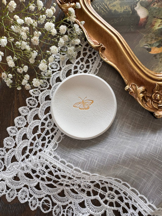 white clay ring dish with gold butterfly design in center, perfect for flat lay kits