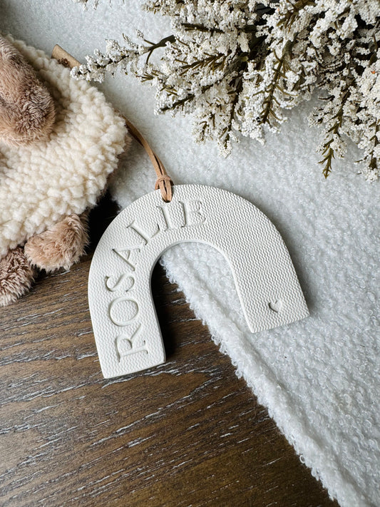 white clay rainbow shaped ornament with embossed name, perfect for baby gift