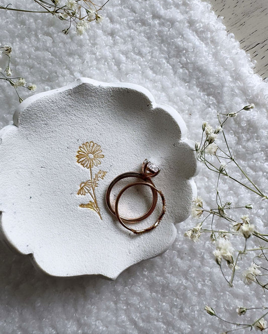 white clay royal edge shaped ring dish with gold daisy design in center