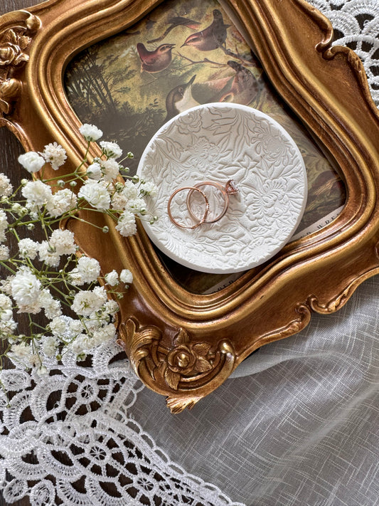 white clay floral pattern textured ring dish for wedding couples in flat lay with flowers and vintage theme