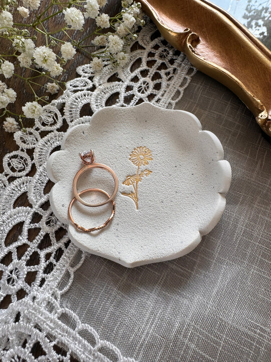 white clay speckled royal edge shaped ring dish with gold daisy design in center